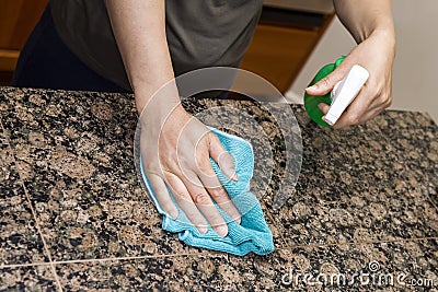 Cleaning Stone Counter-Top in Kitchen Stock Photo