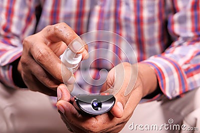 Cleaning Tv remote control with an antibacterial fabric tissue.. Stock Photo