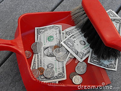 Cleaning up and sweeping up money with a dustpan and broom Stock Photo