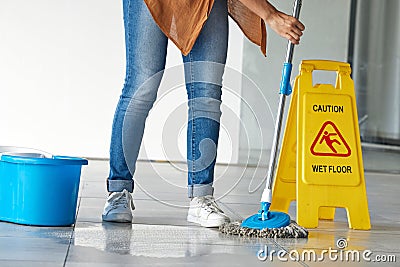 Cleaning, wet floor caution and woman mopping in building for maintenance, health or hygiene. Mop, janitor service and Stock Photo