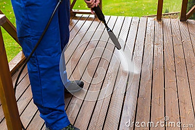 Cleaning wooden terrace with high pressure washer Stock Photo