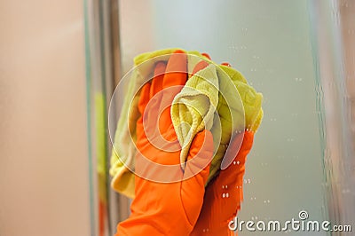 Cleanness in every move. Pretty brunette cleans mirror Stock Photo