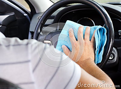 Cleansing car interior and wheel. Male hand disinfecting vihicle inside Stock Photo