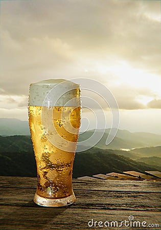 Clear beer glass with full cold beer and foam at the mouth of the glass And water droplets adhere to the edges. Plank or wood Stock Photo