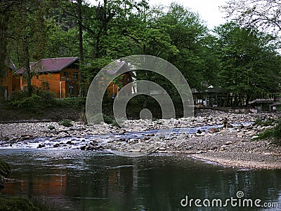 The clear creek in the forest, the wooden house next to the creek Stock Photo