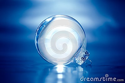 Clear glass Christmas ornament on blue background with empty space Stock Photo