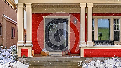 Clear Panorama Entrance of a red home with a pathway and stairs leading to the door and porch Stock Photo