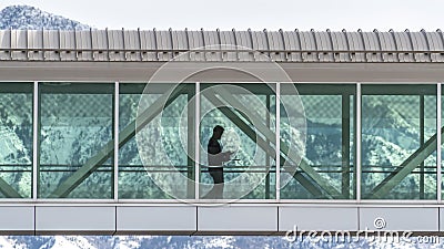 Clear Panorama Skyway connecting buildings with a snowy mountain and cloudy sky background Editorial Stock Photo