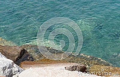 Clear sea water surface, stones and glare Stock Photo