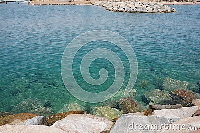 Clear sea water surface, stones and glare Stock Photo