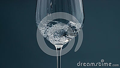 Clear water filling cup closeup. Pure refreshing beverage pour into transparent Stock Photo