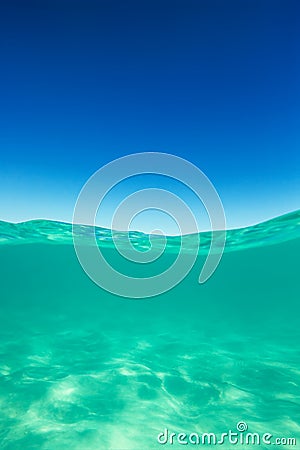 Clear waterline caribbean sea underwater and over with blue sky Stock Photo