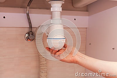 Clearing of blocked hammered polluted plastic U siphon for wash basin, sanitary devices, plumbing fixtures special means cleanser. Stock Photo