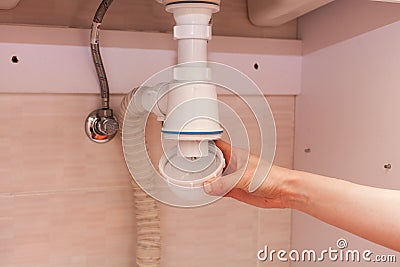 Clearing of blocked hammered polluted plastic U siphon for wash basin, sanitary devices, plumbing fixtures special means cleanser. Stock Photo