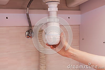 Clearing of blocked hammered polluted plastic U siphon for wash basin, sanitary devices, plumbing fixtures special means cleanser. Stock Photo