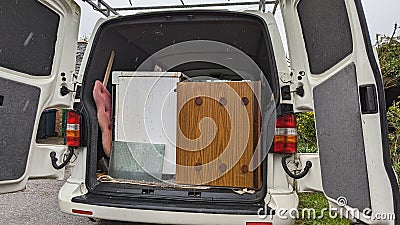 Clearing furniture in the rain into the back of a white van Stock Photo