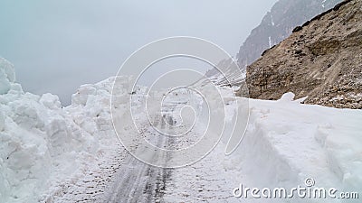 Clearing the road from snow in the mountains. Bad weather in the mountains. Blizzard. Stock Photo
