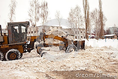 Clearing snow in Russia. Grader clears the way after a heavy snowfall. Tractor clears the road in the courtyard of a multi-storey Editorial Stock Photo