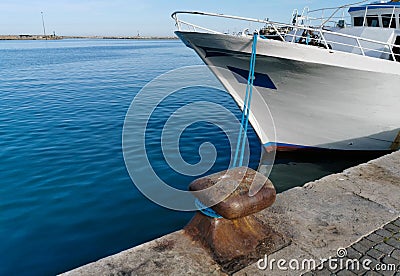 Cleat with blue hawser on the blue sea and white boat Stock Photo