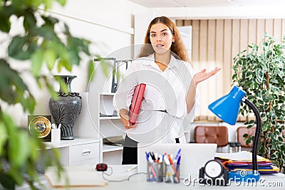 Clerical worker with folder in hands standing in office Stock Photo