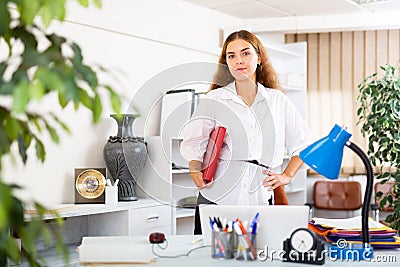 Clerical worker with folder in hands standing in office Stock Photo