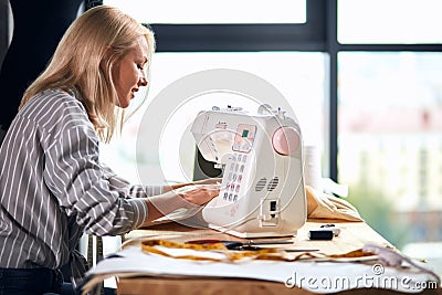 Clever creative talented tailor repairing garment Stock Photo