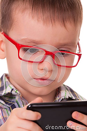 Clever kid is playing with smart cell phone Stock Photo
