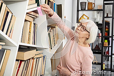 Clever mature woman sticking on shelf hieroglyph Stock Photo