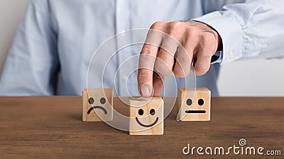 The client`s hand choose the happy face smile face icon Stock Photo