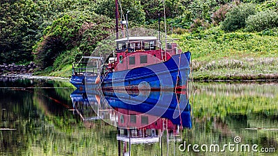 Clifden Bay with an old fishing boat anchored and reflecting in the water Stock Photo