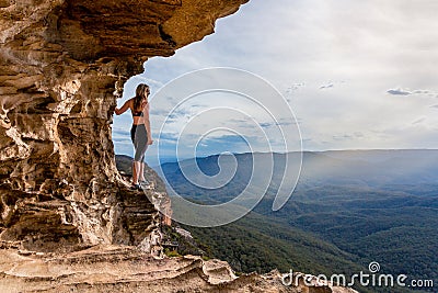 Cliff side cave with mountain valley views Stock Photo