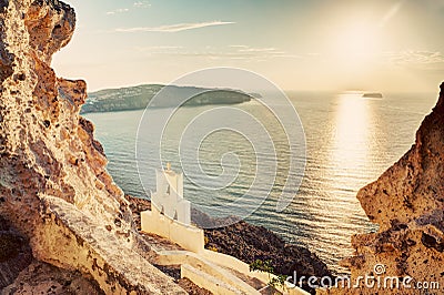 Cliff, volcanic rocks and a traditional chapel on Santorini island, Greece Stock Photo