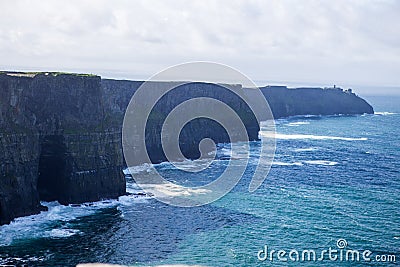 Cliffs of Moher at Alantic Ocean in Western Ireland with waves battering against the rocks Stock Photo