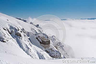 Cliffs on top of the mountain covered with snow with a clear blue sky on a sunny day Stock Photo