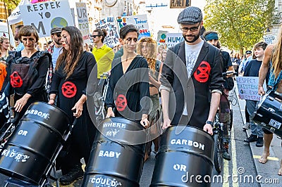 Climate Change protesters pushing oil barrels in strollers at an Extinction Rebellion march Editorial Stock Photo