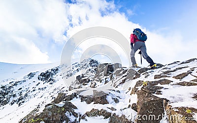 A climber ascending a snow covered ridge Stock Photo