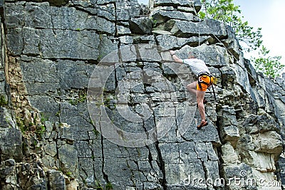 Climber climbing on top of a mountain with a safety Stock Photo