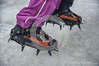 Climber on a frozen waterfall. Crampons close-up on his feet ice climber Stock Photo