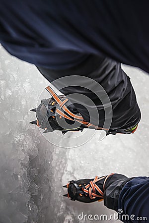 Climber on a frozen waterfall. Crampons close-up on his feet ice climber Stock Photo