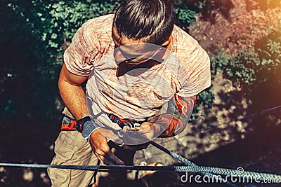 Climber Man Hanging On A Rock On A Rope And Looks Somewhere On The Wall. Extreme Lifestyle Outdoor Activity Concept Stock Photo