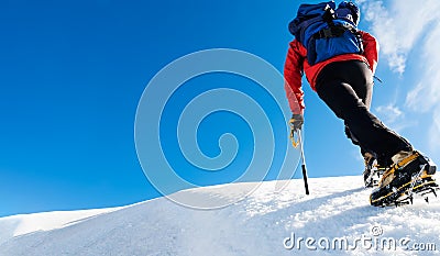 A climber reaches the top of a snowy mountain. Concept: courage, success, perseverance, effort, self-realization. Stock Photo