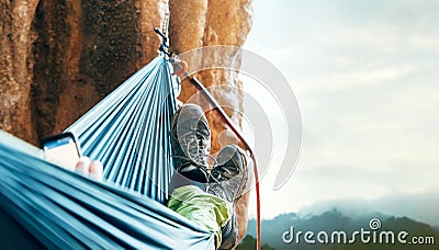 Climber resting in hammock on the vertical cliff wall Stock Photo