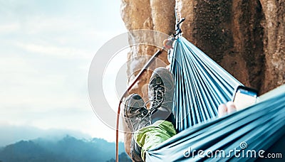 Climber resting in hammock on the vertical cliff wall Stock Photo