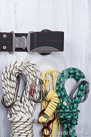 Climber`s belt with different ropes and carbines for insurance lie on a light background Stock Photo