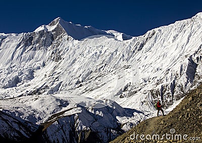 A climber walks through the annapurnas mountains in nepal towards lake tilicho with a spectacular view of the tilicho peak in the Editorial Stock Photo