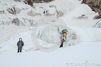 Climbers on glacier traver mountain route attached to the alpinist rope Editorial Stock Photo