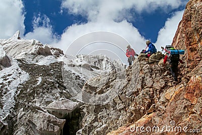 Climbers on glacier traver mountain route attached to the alpinist rope Editorial Stock Photo