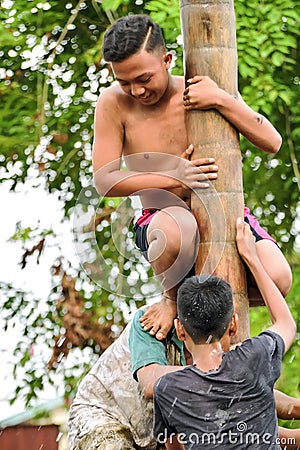 Climbing slippery pole competition or Panjat Pinang indonesian traditinal games Editorial Stock Photo