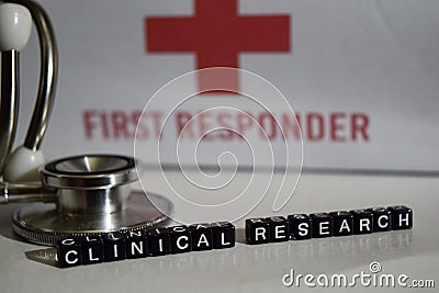 Clinical research message written on wooden blocks. Stethoscope, health care concept. Editorial Stock Photo