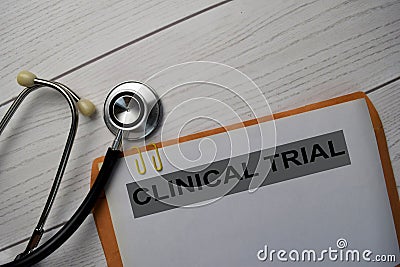 Clinical Trial text with document brown envelope and stethoscope isolated on office desk Stock Photo